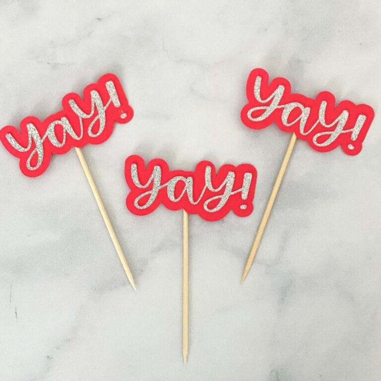 red cupcake toppers that say "yay!"