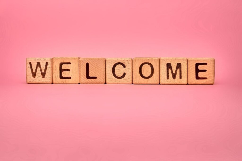 welcome in scrabble letters on pink background